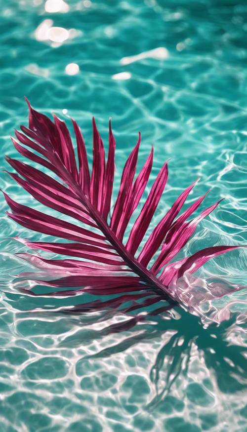 Une feuille de palmier rose foncé plongeant dans une piscine tranquille d’eau turquoise.