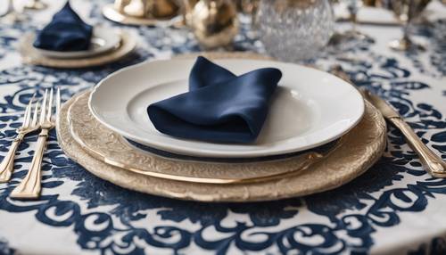 Taplak meja damask modern berwarna biru tua dan krem ​​​​detail di atas meja makan melingkar dengan porselen putih dan peralatan perak.