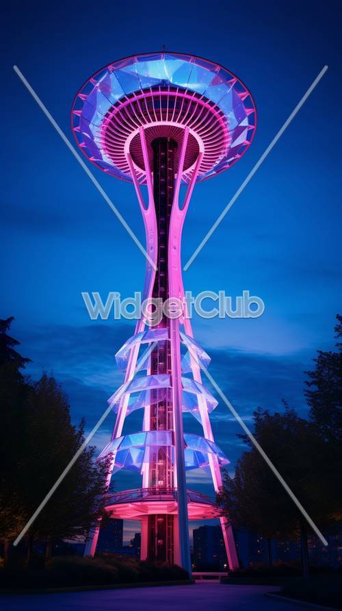 Torre iluminada de color rosa brillante y azul al fondo del atardecer