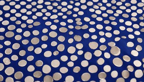 Una giocosa spruzzata di pois bianchi delle dimensioni di una moneta su una texture infinita, simile a un tessuto blu cobalto.