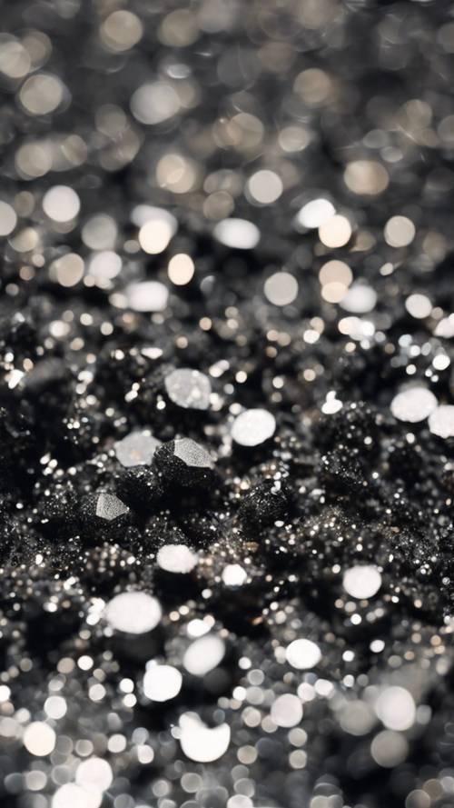 Une vue rapprochée de paillettes argentées dispersées sur une surface noire brillante.