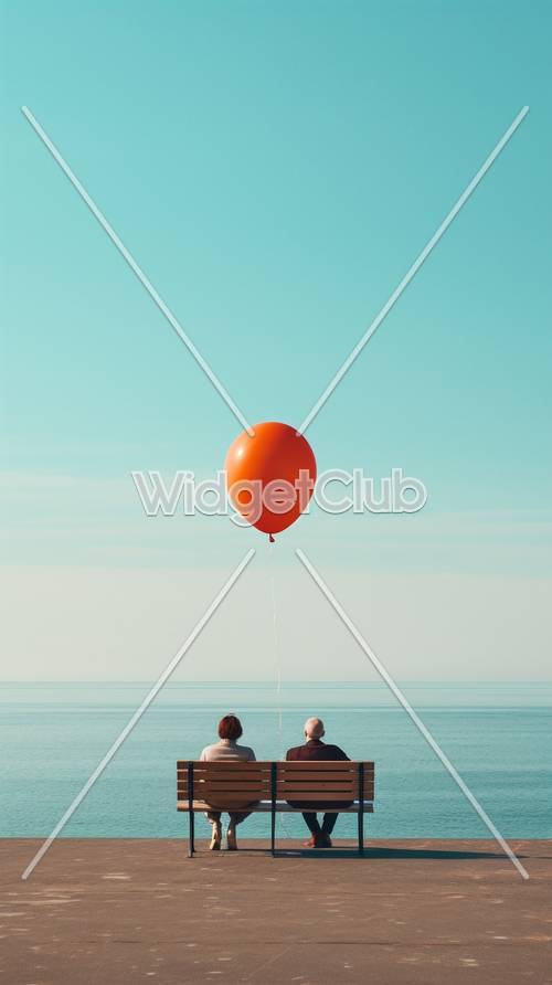Orangefarbener Ballon schwebt über Menschen am Meer