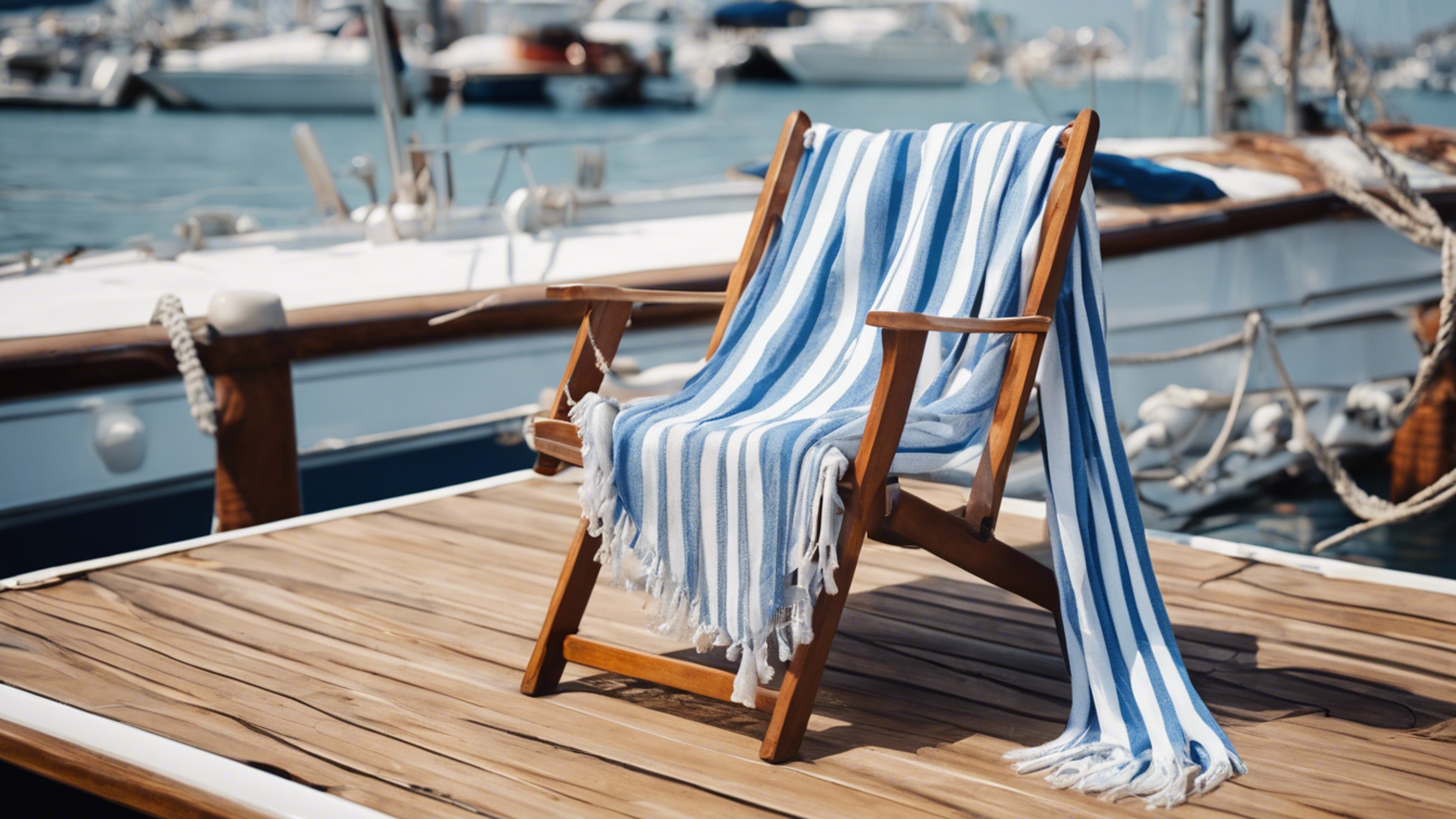 Preppy blue and white striped shawl draped over a teak deck chair on a sailboat. Wallpaper[8e59a438a9aa4e06a25d]
