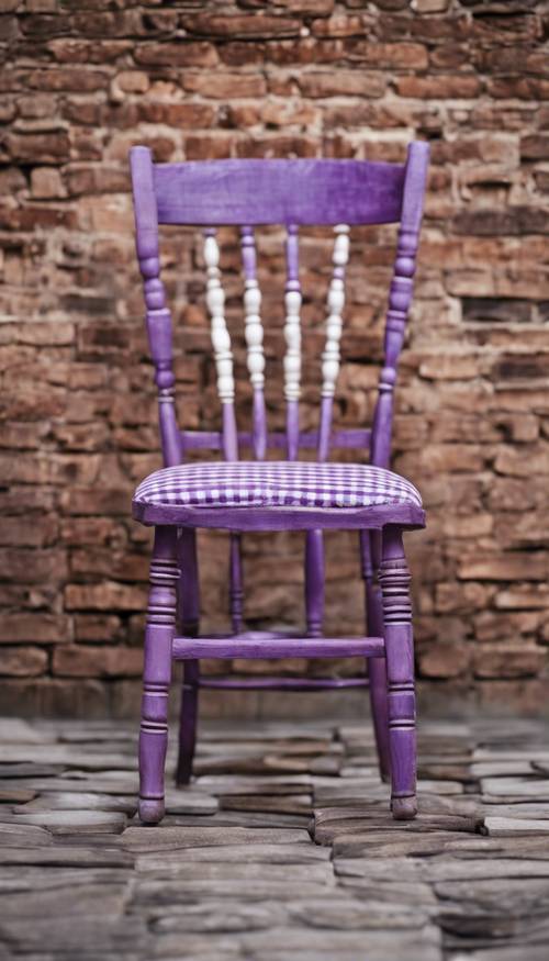 一張孤獨的古董木椅，配有紫色和白色格子的內飾，靠在質樸的磚牆上。