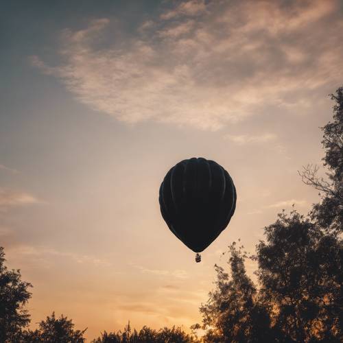 Ein dramatischer schwarzer Ballon in Sternform, der bei Sonnenuntergang am Himmel schwebt.