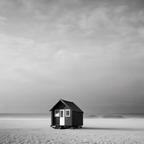 Ein neblig-monochromes Bild einer einsamen Strandhütte an einem ruhigen, leeren Strand.