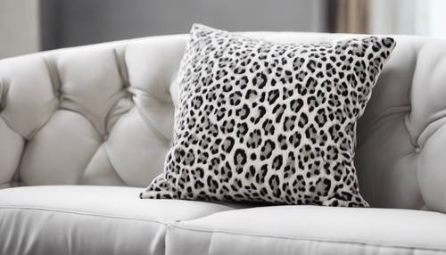Un ensemble de coussins gris à imprimé guépard reposait contre un canapé d’un blanc pur.