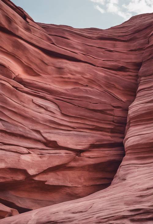 A canyon wall made of layers of pink and red sandstone.