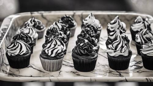Marbled black and white cupcakes on a vintage-styled dish.