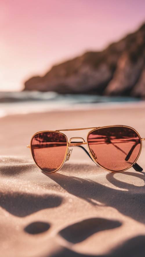 Bir plaj manzarasını yansıtan pembe renkli camlara sahip, altın çerçeveli bir güneş gözlüğü.