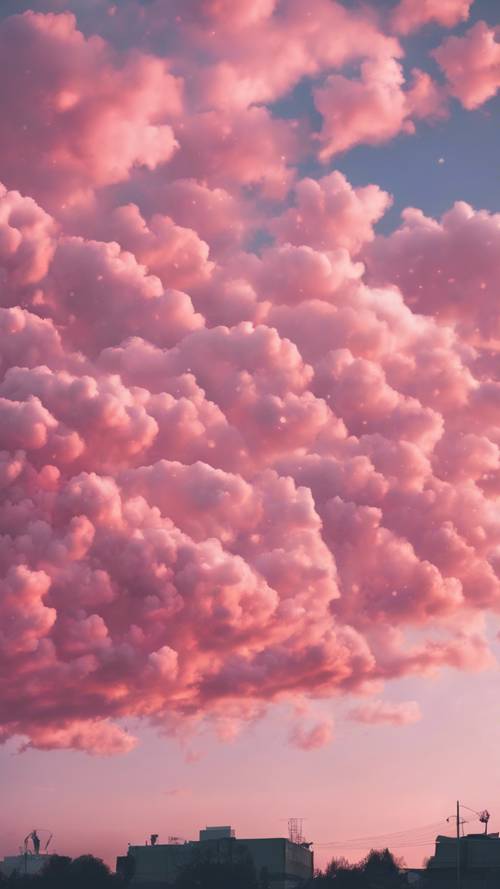 An open sky at dusk, filled with scattered cotton candy pink clouds.