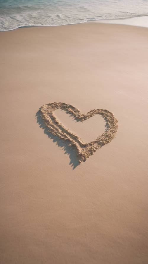 A softly merging gradient heart on a sandy beach with gentle waves caressing it.