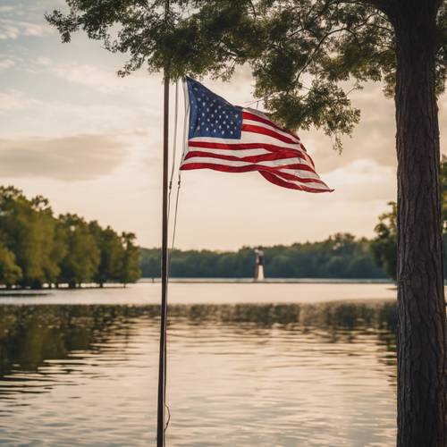 Uma vista serena à beira do lago com uma bandeira americana hasteada a todo o mastro à distância.