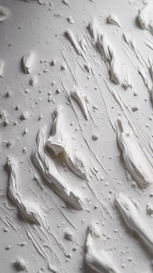 The detailed texture of white paint brushing strokes on a canvas.