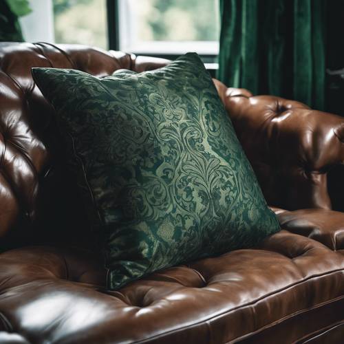 Un rico cojín de damasco de color verde oscuro apoyado sobre un sofá Chesterfield de cuero en un acogedor rincón de lectura.