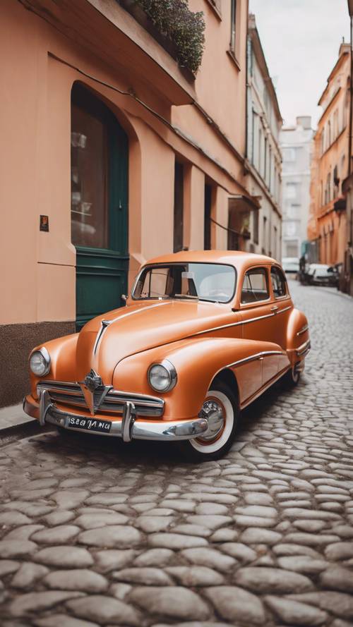 Arnavut kaldırımlı bir sokağa park edilmiş pastel turuncuya boyanmış eski model bir araba.