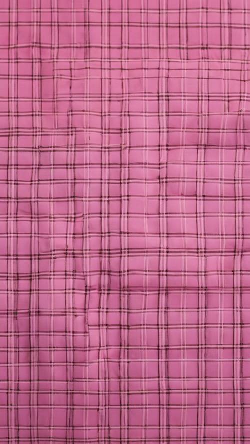 A close-up of a pink plaid fabric with detailed thread patterns