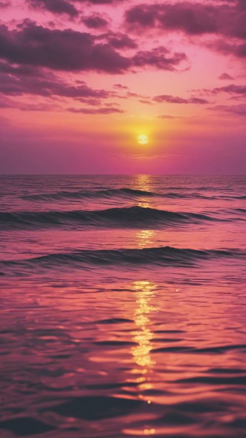 พระอาทิตย์ตกที่น่าทึ่ง โดยที่สีชมพูและสีเหลืองผสมผสานกันบนท้องฟ้า สะท้อนให้เห็นในทะเลอันเงียบสงบ