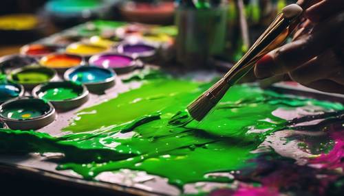 A painter's palette splashed with several shades of fresh neon green paint, a paintbrush resting beside.