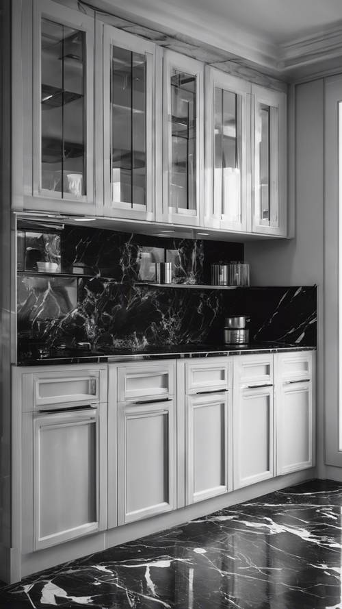 Una cocina monocromática moderna con superficies de mármol negro y gabinetes blancos.