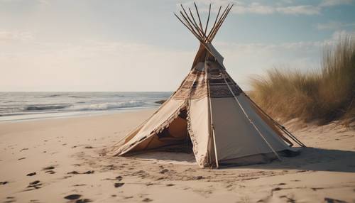 Bohemian tepee on a deserted beach with lazy waves gently caressing the shore.