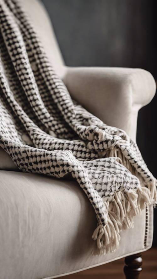 A cozy white throw blanket with cashmere houndstooth pattern draped over a wooden armchair. Tapeta [d744576fdb474158b774]