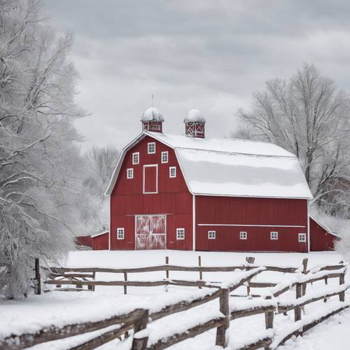 A rustic red barn in a snow-covered, white winter landscape.