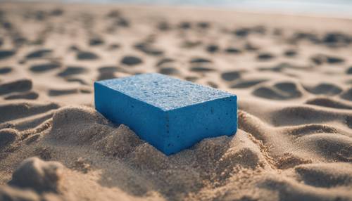 Kumlu bir plajın ortasında duran tek bir mavi tuğla.