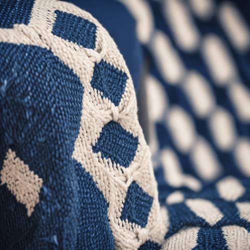 프레피 스타일의 파란색과 흰색 다이아몬드 패턴 스웨터가 의자 위에 걸쳐져 있는 모습.