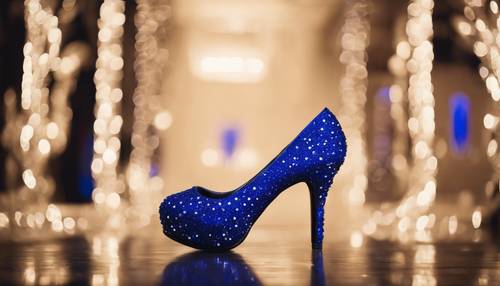 Un paio di scarpe col tacco alto blu royal ornate di strass scintillanti, su una pista da ballo nera lucida.