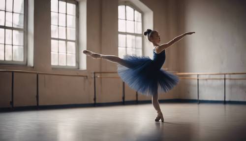 Jovem bailarina fazendo uma pirueta com um tutu azul escuro