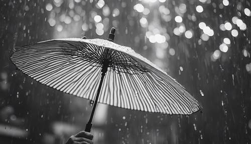 A black and white shot of an umbrella in the rain. Wallpaper [3ad61fe1319443a28d71]