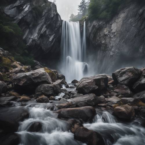 A roaring waterfall cascading over jagged, gray mountain rocks, enveloped in tranquil mist.