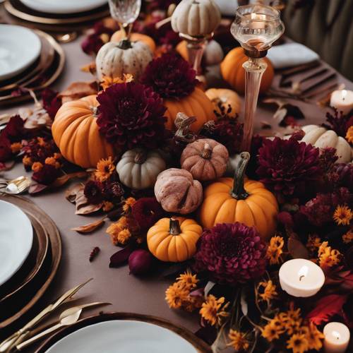 Vue aérienne d&#39;un chemin de table DIY composé de petites citrouilles et de fleurs aux teintes bordeaux audacieuses pour un paysage de table inspiré de l&#39;automne.