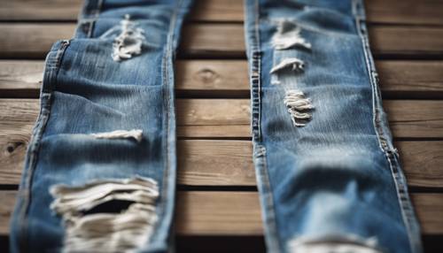 Tattered blue grunge jeans on a rustic wooden bench.