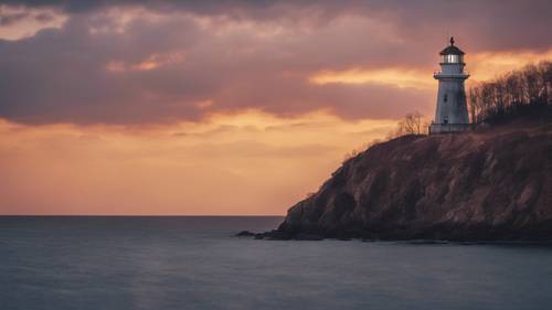 A solitary lighthouse on a cliff edge, its beacon a warm aura against the cold twilight sky. Tapeta [34fdc5e49a60483ab2d4]