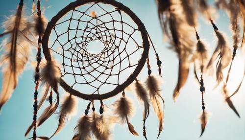 Traditional Native American dreamcatcher, fluttering in a breezy afternoon against the backdrop of a clear azure sky.