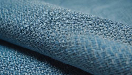 Zbliżenie na niebieską tkaninę lnianą, przedstawiające szczegółowo splot i fakturę.