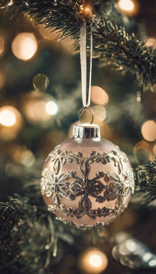 Palline di Natale in stile vintage realizzate in delicato vetro, che scintillano su un albero di Natale invecchiato su uno sfondo di carta da parati decorata.