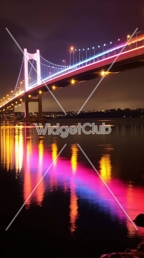 Luces coloridas del puente en la noche reflexionando sobre el agua