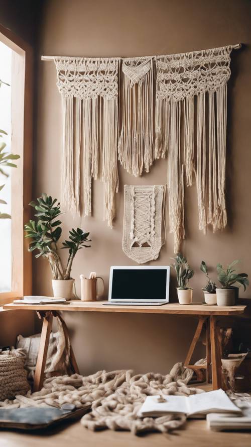 A neatly arranged workspace with beige tones, macrame wall hanging, and wooden desk. Tapet [e343d727e93c434c8f0c]