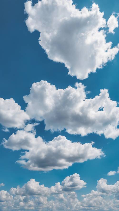 Ein endloser blauer Himmel, übersät mit einer Handvoll weicher, weißer Kumuluswolken.