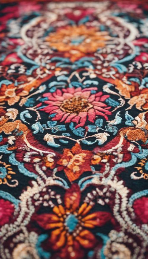 Zbliżenie przedstawiające skomplikowany kwiatowy wzór na kolorowym tureckim dywanie.