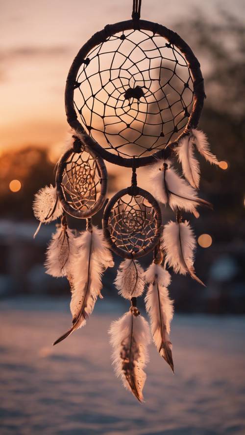Ein kunstvoller Traumfänger aus Leder, der in der Abenddämmerung vor dem Himmel hängt.