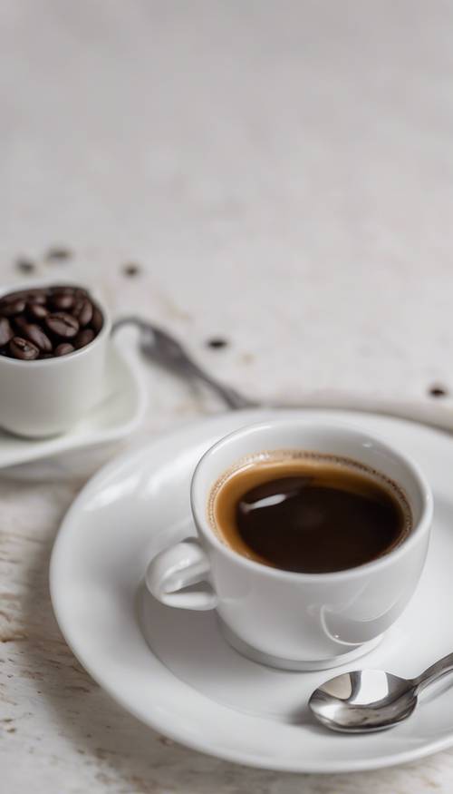 Cangkir kopi putih kecil berisi espresso, diletakkan di atas piring bersama dengan sendok kecil berwarna perak.