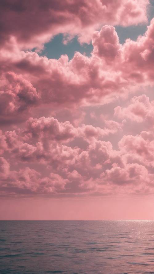 Eine Reihe flauschiger rosa Wolken werfen einen sanften Glanz auf das ruhige Meer.
