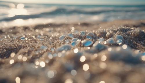 Галечный пляж с мягким бежевым песком, омываемый пенистыми голубыми волнами.