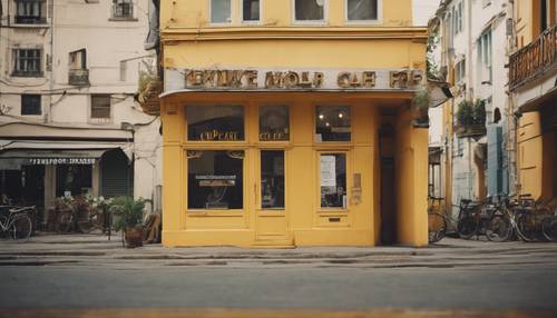 Sebuah bangunan kuning antik dengan kafe menawan di lantai dasar.