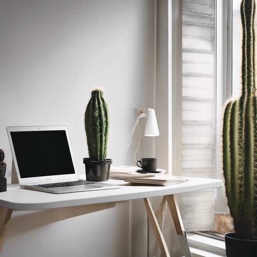 Un ufficio elegante e minimalista con una scrivania bianca e pulita, un MacBook e un cactus.