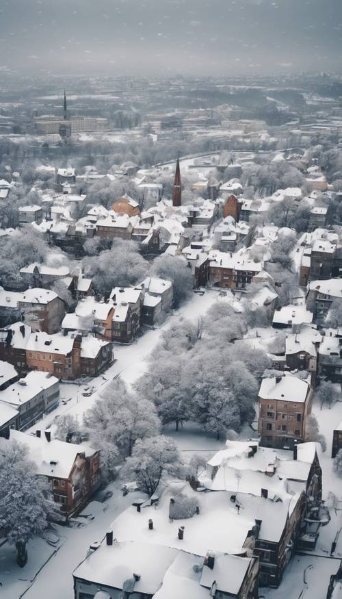 Eine beeindruckende Szene aus der Vogelperspektive einer friedlichen grauen Stadtlandschaft, bedeckt mit frischem weißen Schnee.